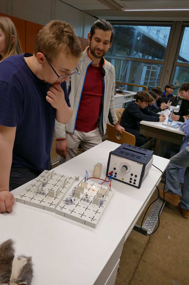 Schüler und Erwachsene experimentieren im Physiksaal