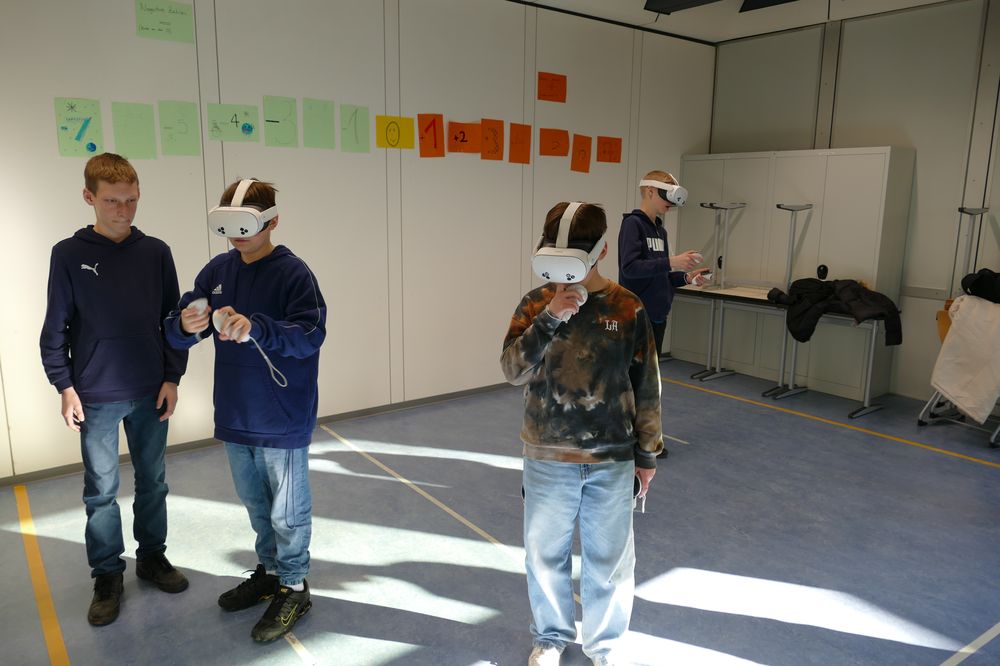 Schüler probieren die VR-Brillen in einem Klassenzimmer aus